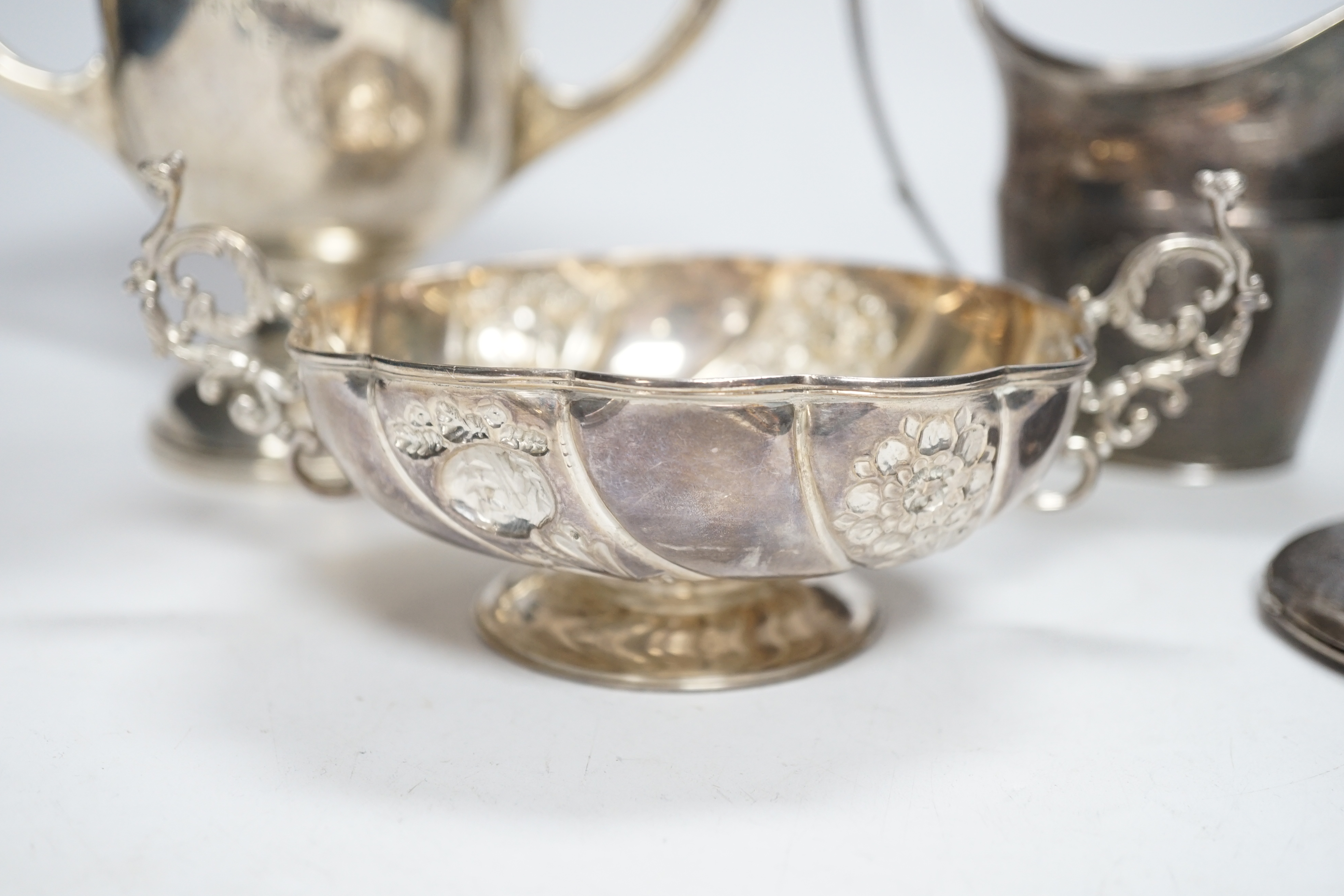 A George III engraved silver helmet shaped cream jug, John Eames, London, 1798, 11.1cm, a Japanese Suzuyo 950 white metal two handled shallow bowl, a George V silver two handled presentation trophy cup and a silver circu